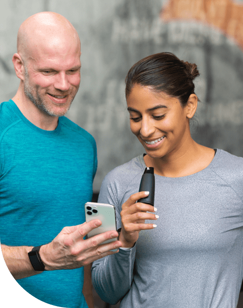 A woman with a lumen device and a man with a cell phone smiling